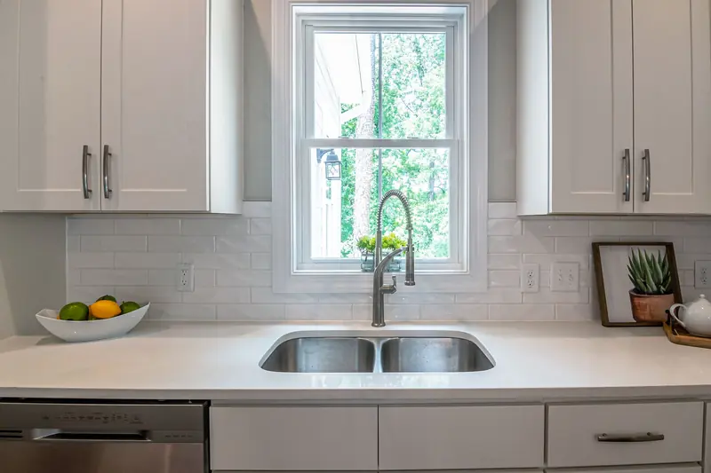White subway tile backsplash behind an undermount sink