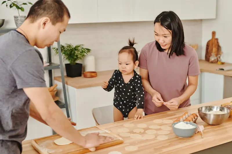 Family making dumplings at a kitchen island