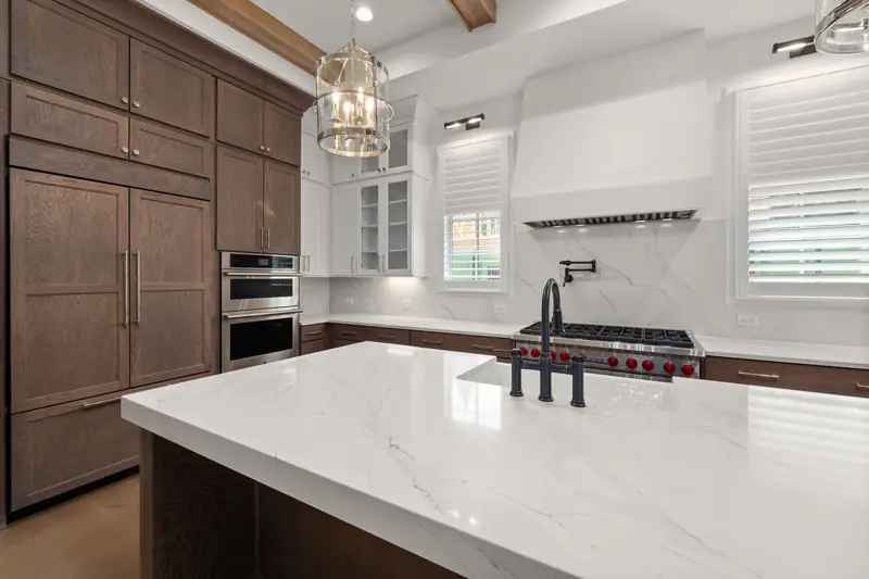 White quartz island countertop with veining and wood cabinets