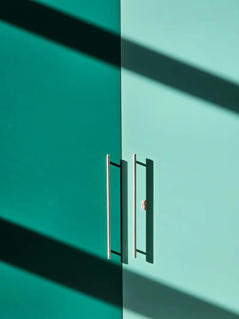 Flat-panel teal cabinet doors with long bar pulls