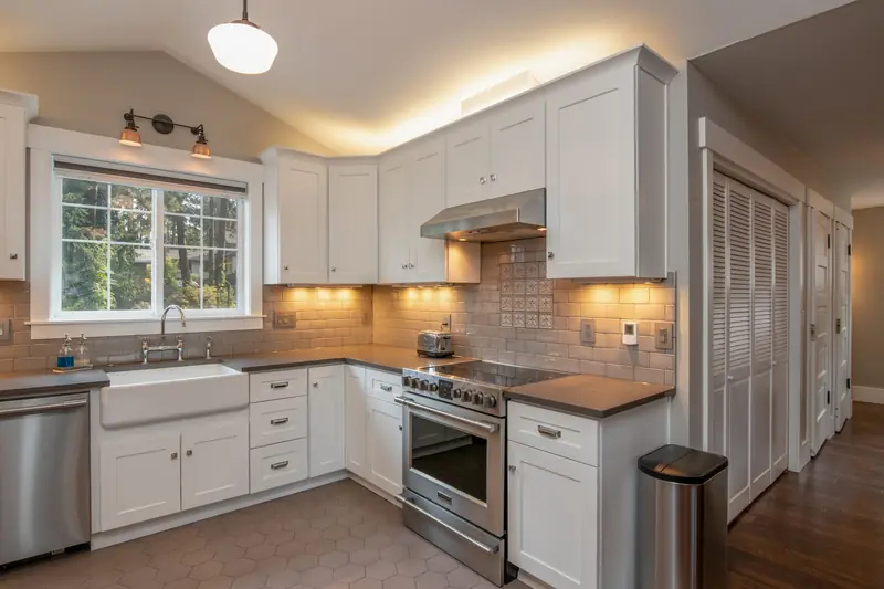 White kitchen with a farmhouse sink and under-cabinet lighting