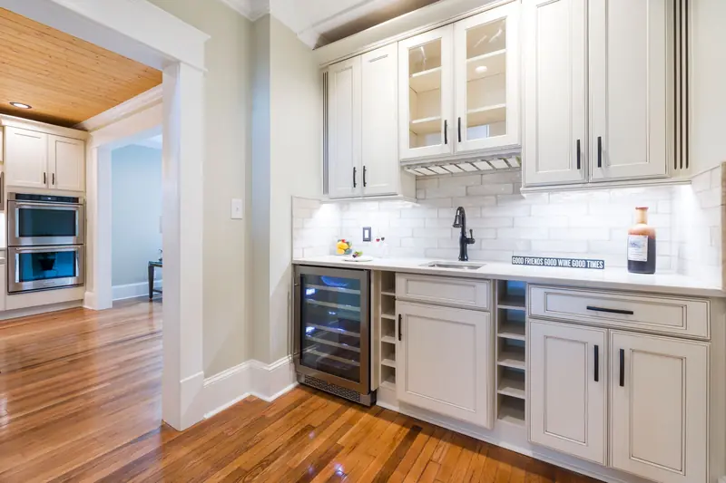 White cabinets with glass-front uppers and a built-in wine fridge