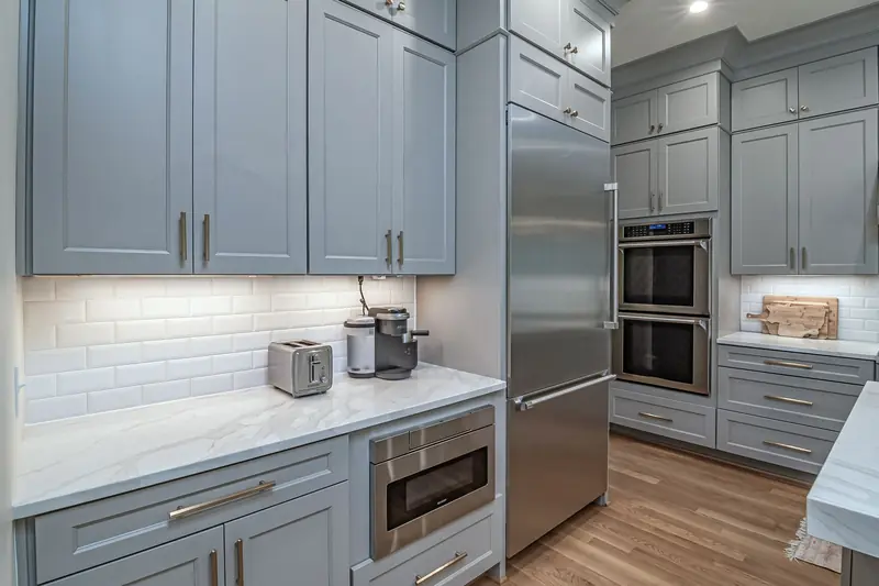 Gray Shaker cabinets with white subway tile and under-cabinet lighting