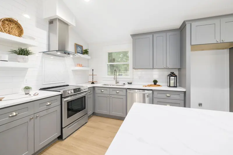 Gray Shaker cabinets with stainless appliances and a white quartz island