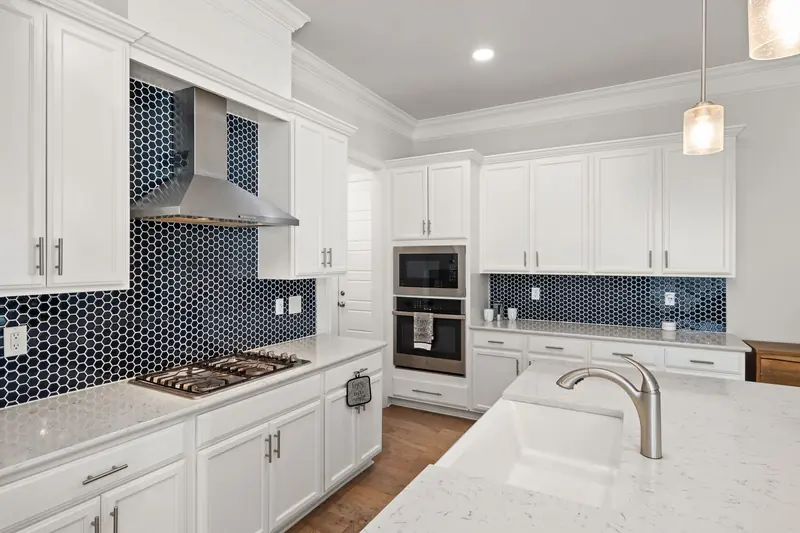 White cabinets with a navy hexagon tile backsplash