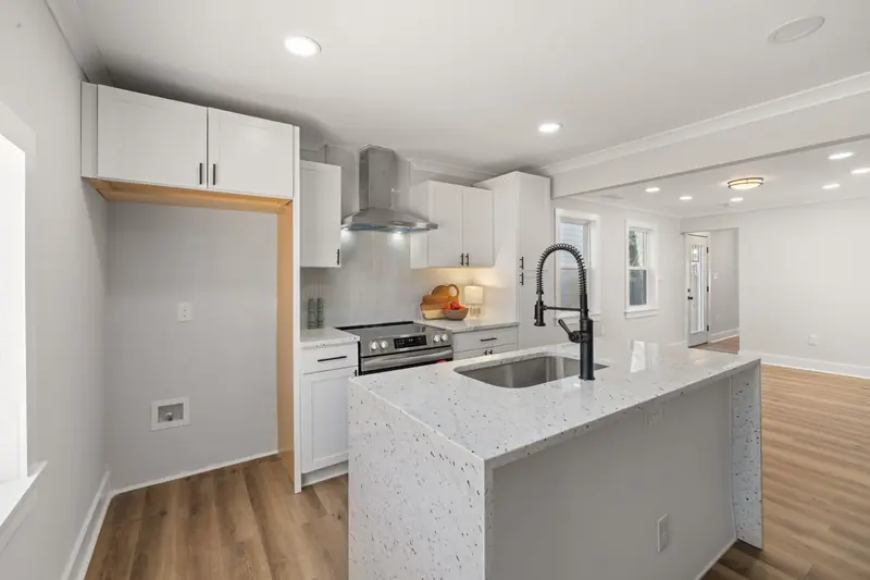 Open-plan white and gray kitchen with a waterfall island