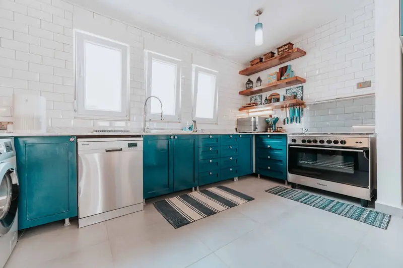 Teal lower cabinets with white subway tile and open shelves