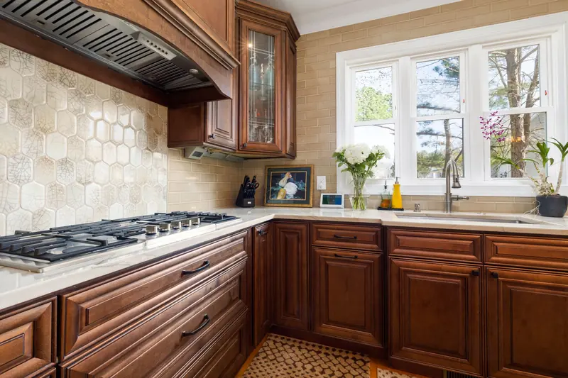 Traditional cherry raised-panel cabinets with a tile backsplash