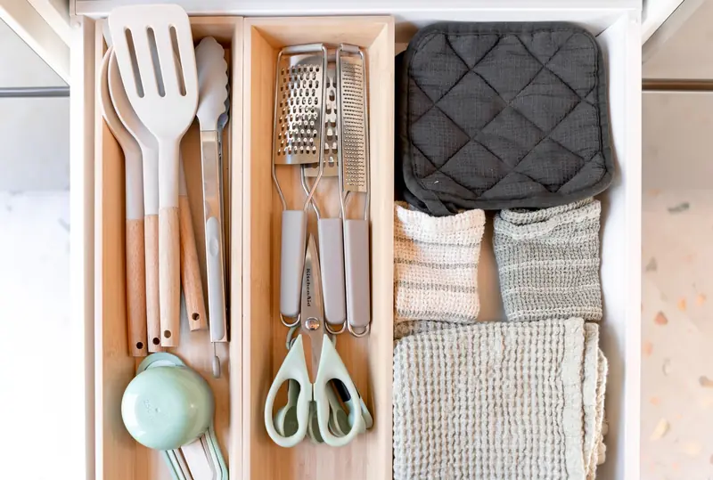 Drawer insert organizing kitchen utensils and towels